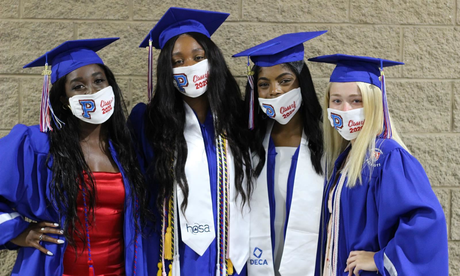 Four graduates pose for a photo